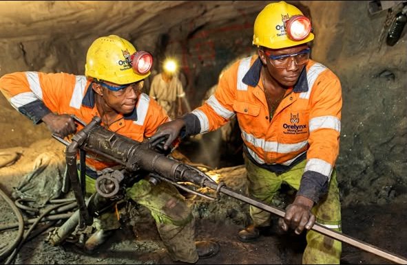 Two ORELYNX miners operating a jackleg drill at the underground face